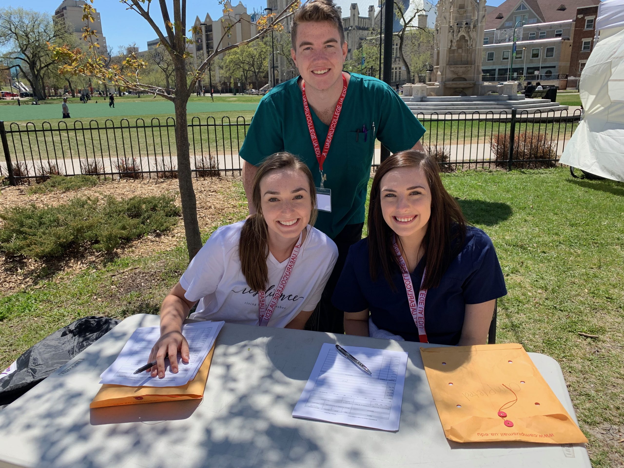 three students sitting at a table, looking at the camera