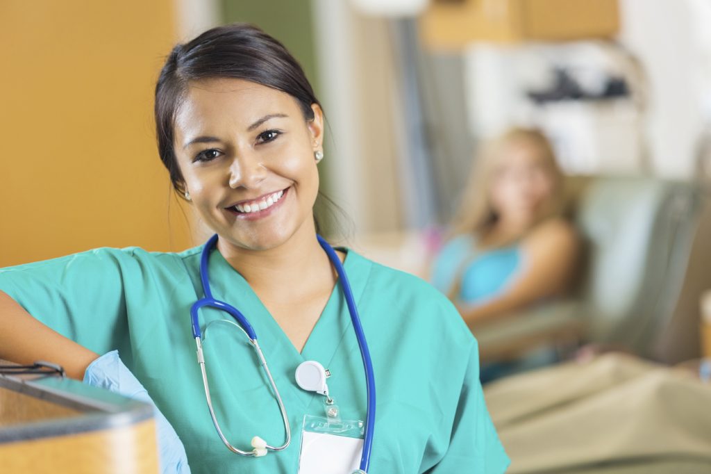 female nurse in scrubs lookin at camera