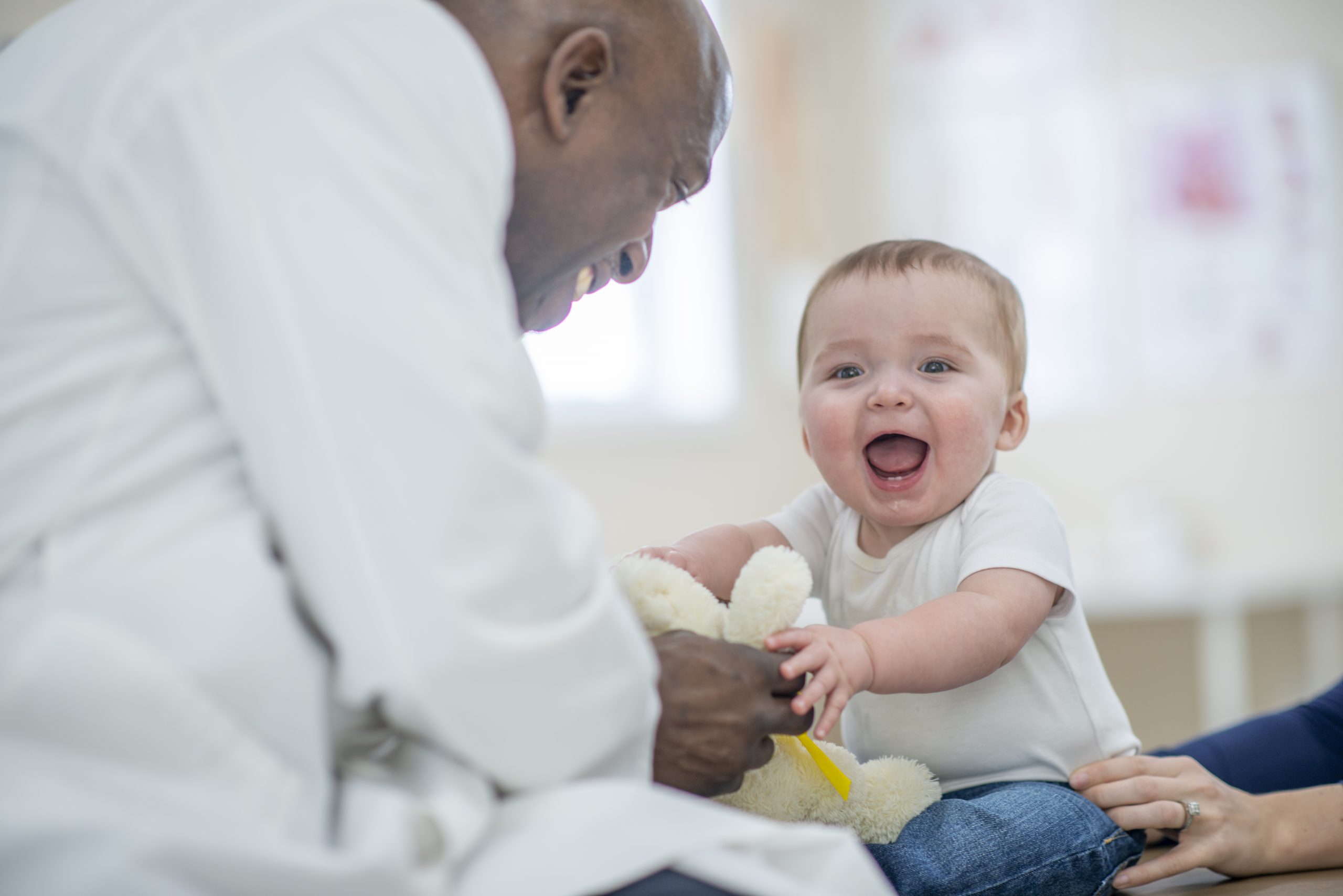 nurse in white coat playing with a baby