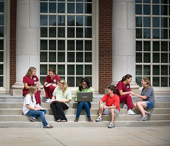 Students sitting on steps of building