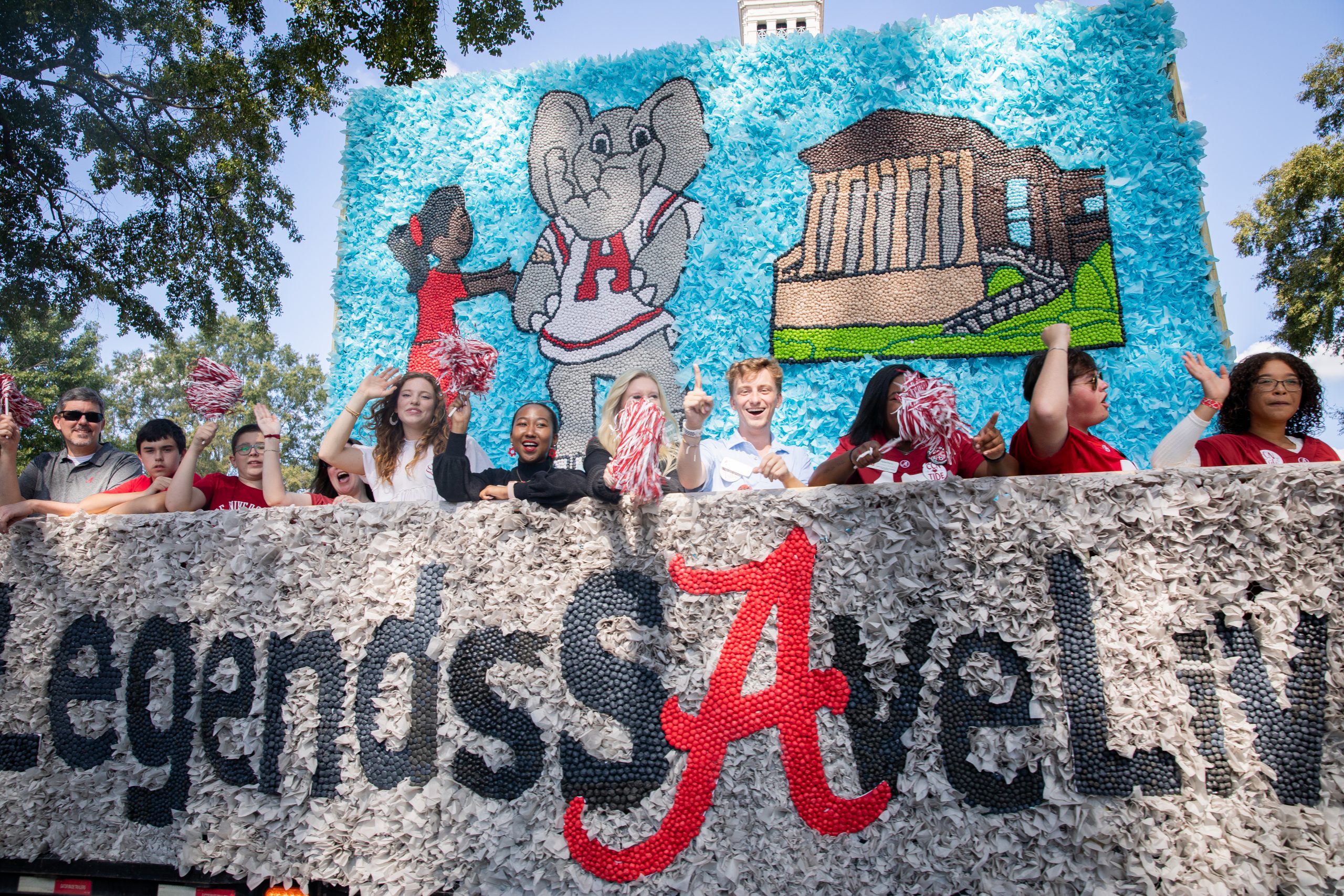 students dressed in Alabama garb cheering from Homecoming float